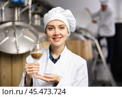 Woman brewer holding glass with malted grain in brewery. Стоковое фото, фотограф Яков Филимонов / Фотобанк Лори