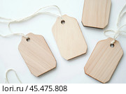 Label tag mockup. Wooden tag set hanging isolated on white background. Blank Gift or Price Tab with string cord knot. Price Label With Rope. Empty space for text. Price labeling or gift tagging. Sale. Стоковое AI-изображение, AI-художник Марина Демидюк / Фотобанк Лори