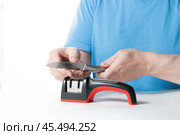 A knife sharpener. A man sharpens a knife on a special universal knife sharpener. Стоковое фото, фотограф Александр Поташев / Фотобанк Лори