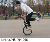 BMX in the Moscow park. Young man doing trick on the bike in the spring day. Extreme sports is very popular among youth. 2019. Редакционное фото, фотограф YuryKara / Фотобанк Лори