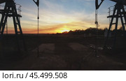 Moving between two working oil pumps to sunset. Стоковое видео, видеограф Михаил Коханчиков / Фотобанк Лори