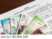 Договор о предоставлении социальных услуг и деньги лежат на столе. Стоковое фото, фотограф Игорь Низов / Фотобанк Лори