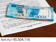 Договор о предоставлении социальных услуг и стопка денег лежат на столе. Стоковое фото, фотограф Игорь Низов / Фотобанк Лори