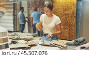 Girl customer looks closely at carpet examples in a hardware store. Стоковое видео, видеограф Яков Филимонов / Фотобанк Лори