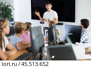 Young male teacher speaking to underage attendees of computer courses. Стоковое фото, фотограф Яков Филимонов / Фотобанк Лори
