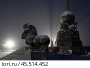 Скульптурный комплекс «Центр Азии», город Кызыл, Республика Тыва (Тува), Сибирь, Россия. Обелиск в виде шара, который держат три мифических существа — арзылана, и скульптуры животных буддийского гороскопа. Ночной зимний пейзаж с памятником. Туристическая достопримечательность Кызыла. Редакционное фото, фотограф Андрей Степанов / Фотобанк Лори