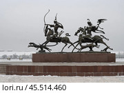 Скульптурная композиция «Царская охота», город Кызыл, Республика Тыва (Тува), Сибирь, Россия. Скульптурное изображение двух всадников — мужчины и женщины, на соколиной охоте. Рядом с ними бегут две охотничьи собаки. Зимний вид на памятник. Туристическая достопримечательность Кызыла. Редакционное фото, фотограф Андрей Степанов / Фотобанк Лори