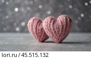 The banner. Background for Valentine's Day. Knitted hearts with festive lights in the form of a side in the background. a mock-up of an invitation card for a Valentine's Day party, a place to copy. Стоковое AI-изображение, AI-художник Photojuli / Фотобанк Лори