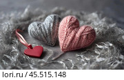 The banner. Background for Valentine's Day. Knitted hearts with festive lights in the form of a side in the background. a mock-up of an invitation card for a Valentine's Day party, a place to copy. Стоковое AI-изображение, AI-художник Photojuli / Фотобанк Лори