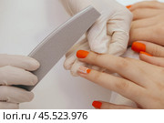manicure worker smoothing customers nails with nail file. Стоковое фото, фотограф Сергей Толмачёв / Фотобанк Лори