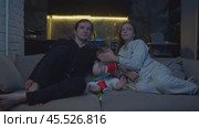 Parents shield their little daughter's eyes from information on TV that they feel is not suitable for her age. Стоковое видео, видеограф Strunov David / Фотобанк Лори