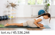 Experienced girl fitness club teacher performs pigeon asana, eka pada rajakapotasana. Стоковое фото, фотограф Яков Филимонов / Фотобанк Лори