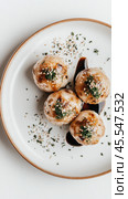 Вкусные шарики такояки на белой тарелке с зеленью и соевым соусом — кулинарное наслаждение для гурманов. Стоковое AI-изображение, AI-художник ФотоИнтеллект / Фотобанк Лори
