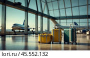 Travel suitcases stand on the floor of the airport terminal. Стоковое AI-изображение, AI-художник Boris Vasilenko / Фотобанк Лори