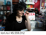 06.04.2023, Москва. Международная ярмарка интеллектуальной литературы «non/fictioNвесна» в Гостином дворе. Девушка с книгой на ярмарке. Редакционное фото, фотограф Дмитрий Киселёв / Фотобанк Лори