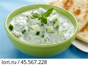 Traditional Greek Tzatziki dip sauce made with cucumber sour cream. Yogurt sauce with dill, lemon juice, olive oil. Served with toasted Za'atar Pita bread. Top view. Tarator, cacik or tartar. Стоковое AI-изображение, AI-художник Марина Демидюк / Фотобанк Лори