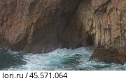 Sea waves enter a cave in rock and form splashes. Стоковое видео, видеограф Михаил Коханчиков / Фотобанк Лори