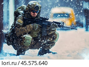 Soldier in full gear with an automatic weapon in populated area in snowy winter. Стоковое AI-изображение, AI-художник Владимир Григорьев / Фотобанк Лори