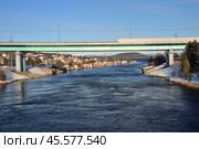Knyazhaya Guba Village, urban settlement of Zelenoborsky, Kandalaksha district, Murmansk region, March 23, 2024: Automobile bridge across Knyazhegubskaya hydroelectric power station canal at confluence in Knyazhaya Guba of White Sea. Редакционное фото, фотограф Алексей Антипов / Фотобанк Лори