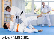 Karate sensei working out fighting techniques in kumite with young guy. Стоковое фото, фотограф Яков Филимонов / Фотобанк Лори