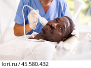 African American undergoing cosmetic facial treatment using cold hammer. Стоковое фото, фотограф Яков Филимонов / Фотобанк Лори