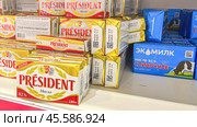 Moscow December 04, 2024, Butter in packaging on a store counter. Concept of increasing prices for butter. Refrigerator in a grocery store with briquettes of natural butter. Редакционное фото, фотограф Скрипачев Антон / Фотобанк Лори