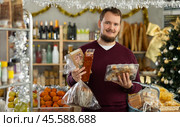 Man chooses turron, panellets and panettone. Стоковое фото, фотограф Яков Филимонов / Фотобанк Лори