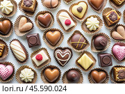 An assortment of exquisite chocolates, white, dark and milk chocolate. Background of sweets. The concept of Valentine's Day. Стоковое AI-изображение, AI-художник Photojuli / Фотобанк Лори