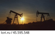 Working oil pumps silhouette against sunset. Стоковое видео, видеограф Михаил Коханчиков / Фотобанк Лори