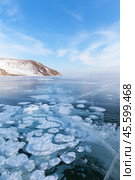 Scenic winter landscape with white gas bubbles on blue ice surface on frozen Baikal Lake on cold winter sunny day. Endless icy expanses to the horizon. Winter natural background. Ice travel and outdoors. Стоковое фото, фотограф Виктория Катьянова / Фотобанк Лори
