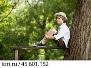 Boy sits on a wooden bench. Стоковое фото, фотограф Дмитрий Киселёв / Фотобанк Лори