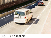 Fast moving Volkswagen Caravelle T5 on the city road. White van riding on street. Commercial auto in fast motion with blurred background. Speeding in the city concept. Редакционное фото, фотограф Константин Григорьев / Фотобанк Лори