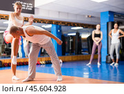 Girl performing knee kick with wristlock to male opponent in sparring. Стоковое фото, фотограф Яков Филимонов / Фотобанк Лори