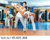 Asian woman performing elbow strike and wristlock to male opponent during self defence training. Стоковое фото, фотограф Яков Филимонов / Фотобанк Лори