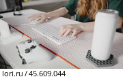 Player uses gaming keyboard. Young gamer plays video game. Hands close up typing on computer keyboard in lighted bright room. Girl teenager working daytime. Concept cyberspace and hobby. Стоковое видео, видеограф Енваев Андрей / Фотобанк Лори