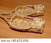 С давних пор на Руси принято отмечать Лаптев день 22 февраля. Липовые лапти. Лапти — низкая обувь, распространённая в Северной и Восточной Европе в старину, и бывшая в широком употреблении в сельской местности до 1930-х годов, сплетённая из древесного лыка (липовые, вязовые, ивовые), берёсты или пеньки. Стоковое фото, фотограф Сергей Елизарьев / Фотобанк Лори