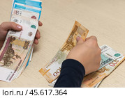 Мальчик пересчитывает российские купюры. Стоковое фото, фотограф Игорь Низов / Фотобанк Лори