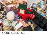 Женщина выбирает елочные игрушки во время предпраздничные распродажи новогодних товаров в Главном универсальном магазине (ГУМ) в центре города Москвы, Россия. Редакционное фото, фотограф Николай Винокуров / Фотобанк Лори