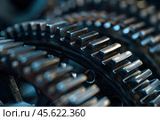 Close up of interlocking gears working together in perfect harmony. Стоковое AI-изображение, AI-художник Иван Рябоконь / Фотобанк Лори