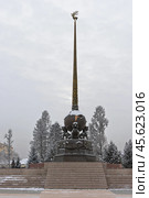 Обелиск «Центр Азии», город Кызыл, Республика Тыва (Тува), Сибирь, Россия. Обелиск в виде шара, олицетворяющего планету Земля, который держат три мифических существа — арзылана. Шпиль обелиска венчает «солнечный олень» — символ Тувы. Зимний вид на памятник. Туристическая достопримечательность Кызыла. Редакционное фото, фотограф Андрей Степанов / Фотобанк Лори