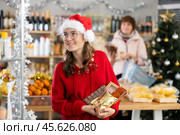 Adolescence girl customer choose consider desserts and sweet snacks, woman in background. Стоковое фото, фотограф Яков Филимонов / Фотобанк Лори