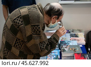 Мужчина сквозь очки рассматривает книги на выставке (2022 год). Редакционное фото, фотограф Дмитрий Киселёв / Фотобанк Лори