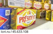 Moscow December 04, 2024, Butter in packaging on a store counter. Concept of increasing prices for butter. Refrigerator in a grocery store with briquettes of natural butter. Редакционное фото, фотограф Скрипачев Антон / Фотобанк Лори