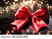 Elegant bow made of satin red ribbon on a shiny black background. Стоковое AI-изображение, AI-художник Photojuli / Фотобанк Лори