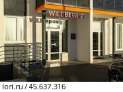 Вывеска над входом в пункт выдачи маркетплейса Wildberries в жилом многоэтажном доме в городе. Редакционное фото, фотограф Sergei Gorin / Фотобанк Лори