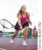 Young forcefully teenage girl playing tennis close to net on court. Стоковое фото, фотограф Яков Филимонов / Фотобанк Лори