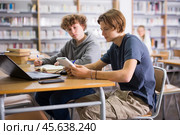 Two teenage friends are reading books and preparing for exams in school library. Стоковое фото, фотограф Яков Филимонов / Фотобанк Лори