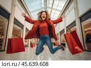 A young woman dressed in a red coat jumps with excitement in a vibrant shopping mall, holding red shopping bags, embodying the joy of shopping. Стоковое AI-изображение, AI-художник Sergey Grishin / Фотобанк Лори