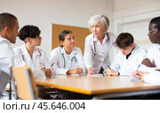 Elderly female professor of medicine giving lecture to group of internship doctors. Стоковое фото, фотограф Яков Филимонов / Фотобанк Лори