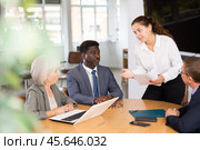 Positive business partners engaged in conversation sitting around table. Стоковое фото, фотограф Яков Филимонов / Фотобанк Лори